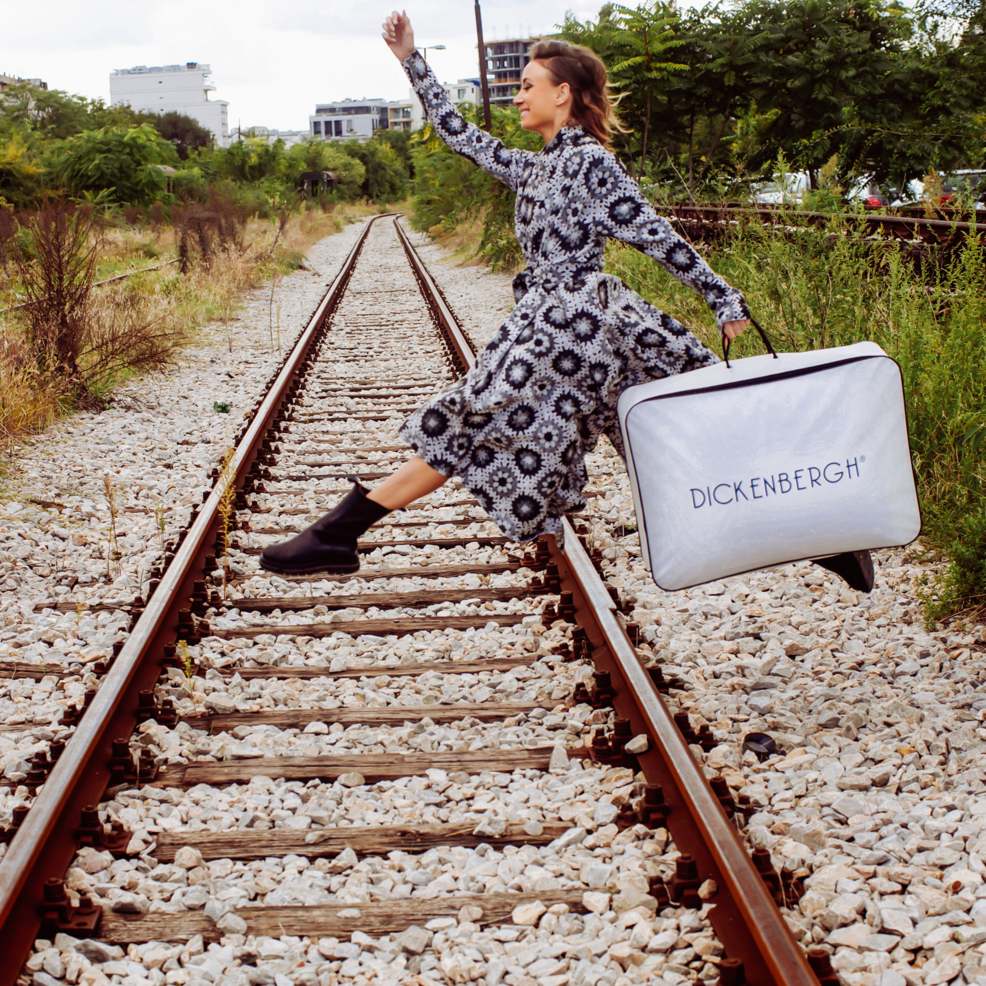 Female Model jumping over train tracks with Dickenbergh Bag